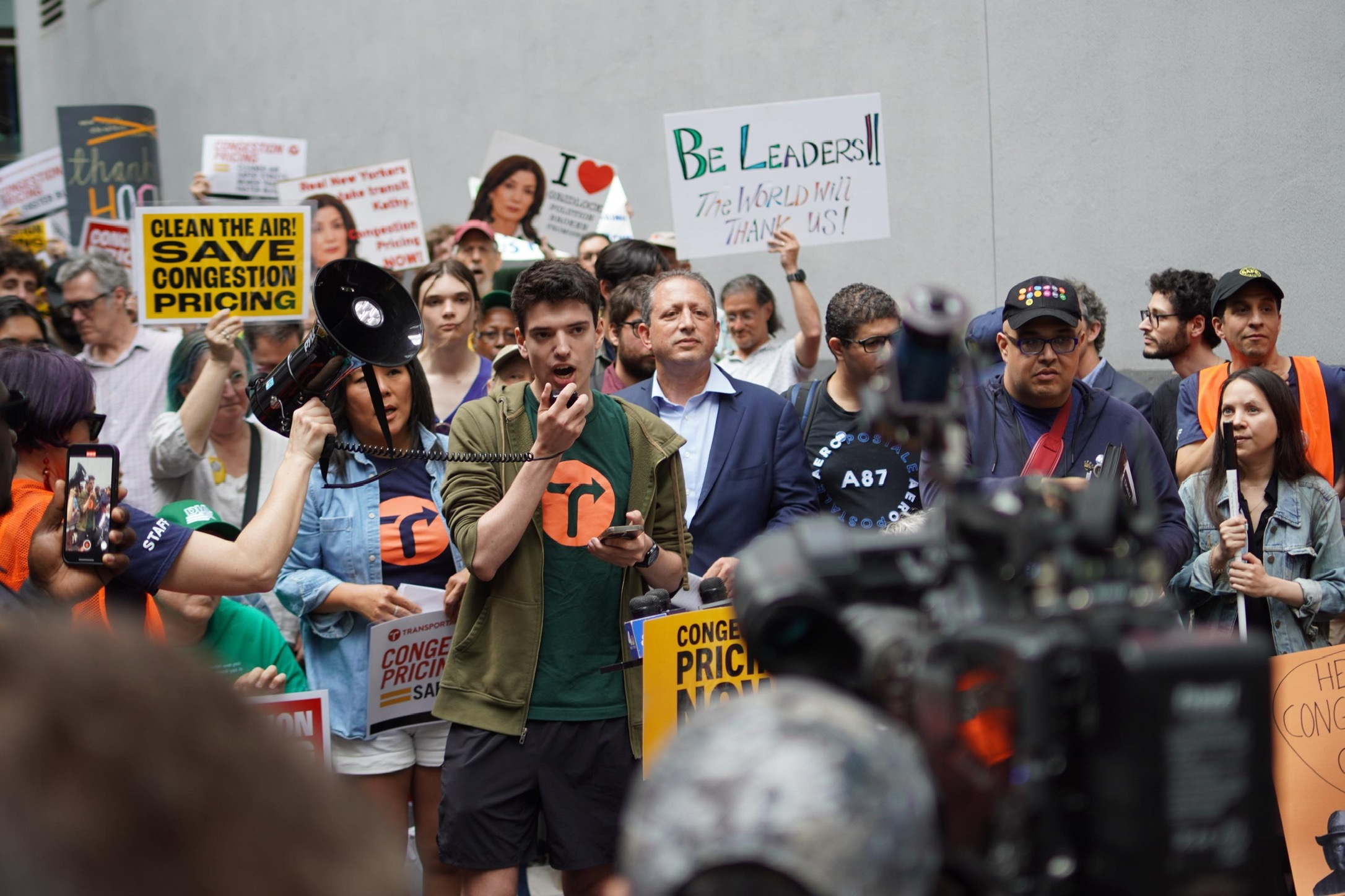 Miles speaking into a megaphone at a rally for congestion pricing